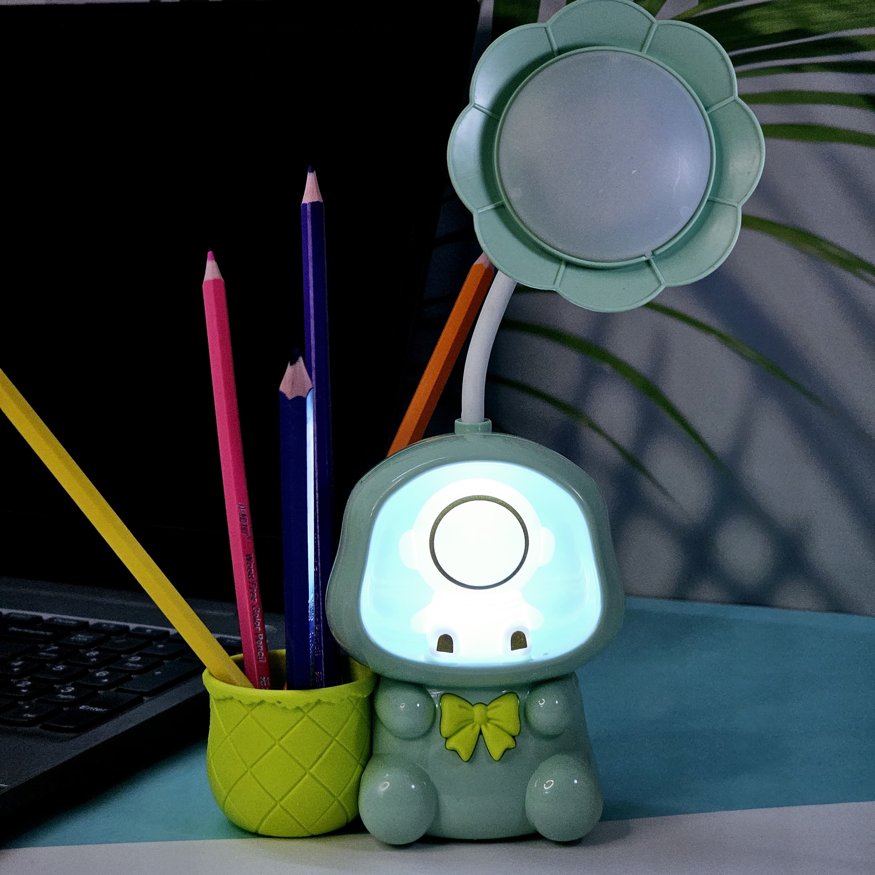 Colorful Usmile Toys children's desk lamps, shaped like cute astronauts with light-up heads and built-in compartments for pencils, ideal for a child's study area or bedroom." www.usmile.toys